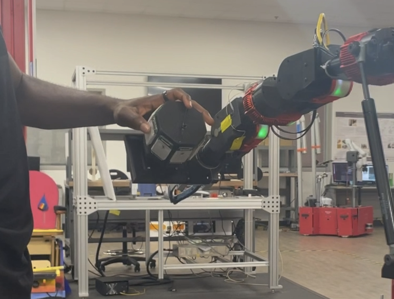 A participant grasping the sensorized OctoCan end effector mounted on a RE2 robotic arm.